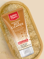 Tube of Golden Pearl Brightening Rice Cleanser on a bed of rice grains