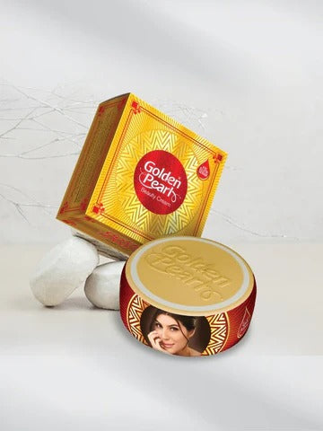 Shimmer Cream 1 jar and its matching yellow and red packaging box, styled with three white pearls on a light gray marble-textured background.
