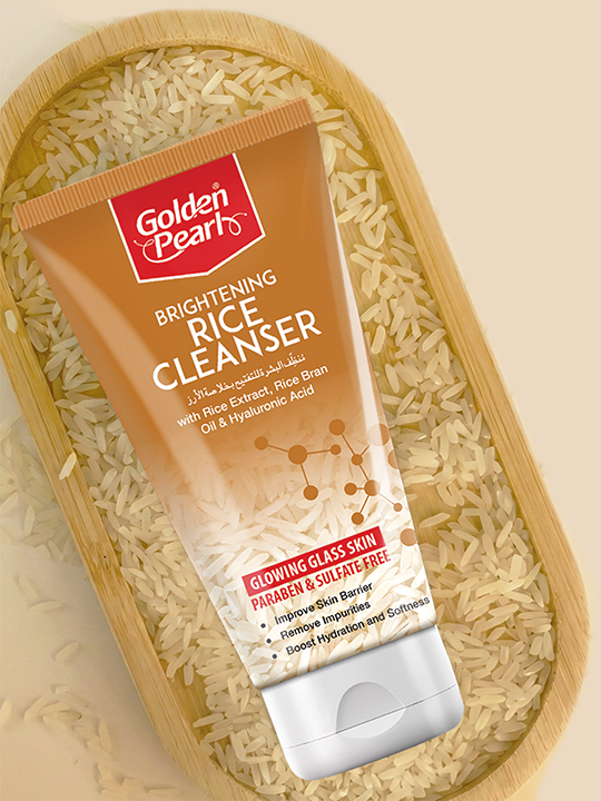 Tube of Golden Pearl Brightening Rice Cleanser on a bed of rice grains